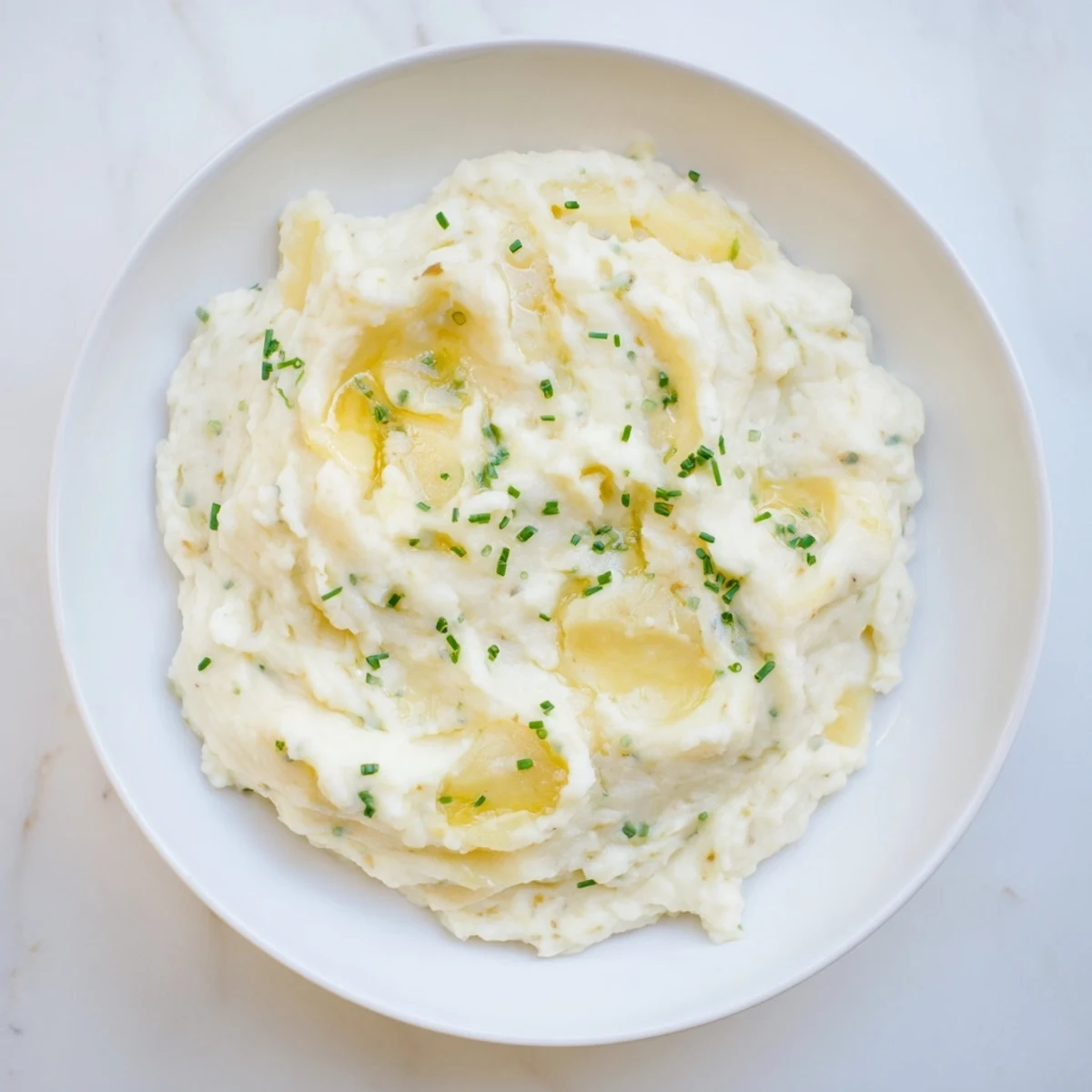 Fluffy, creamy Garlic Mashed Potatoes, perfect side; topped with fresh herbs and ready to serve.