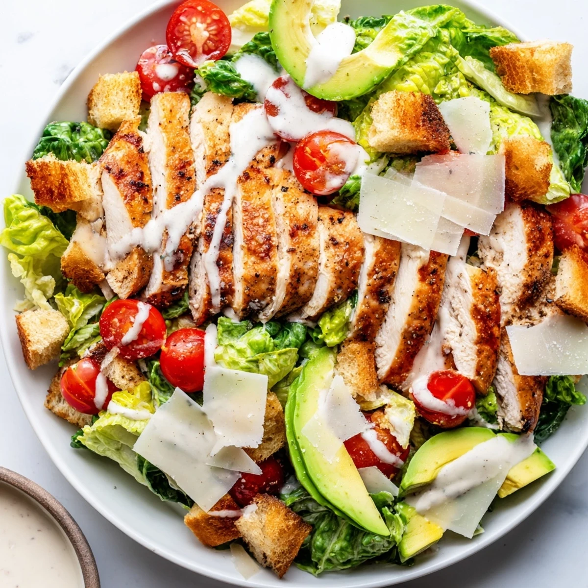 Enjoy this easy Chicken Caesar Salad with avocado boasting grilled chicken and Parmesan, perfect for a meal.