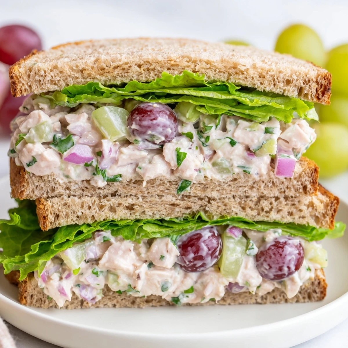 Golden toasted Chicken Salad Sandwich with Grapes on a plate, paired with potato chips for an easy picnic-ready American lunch.