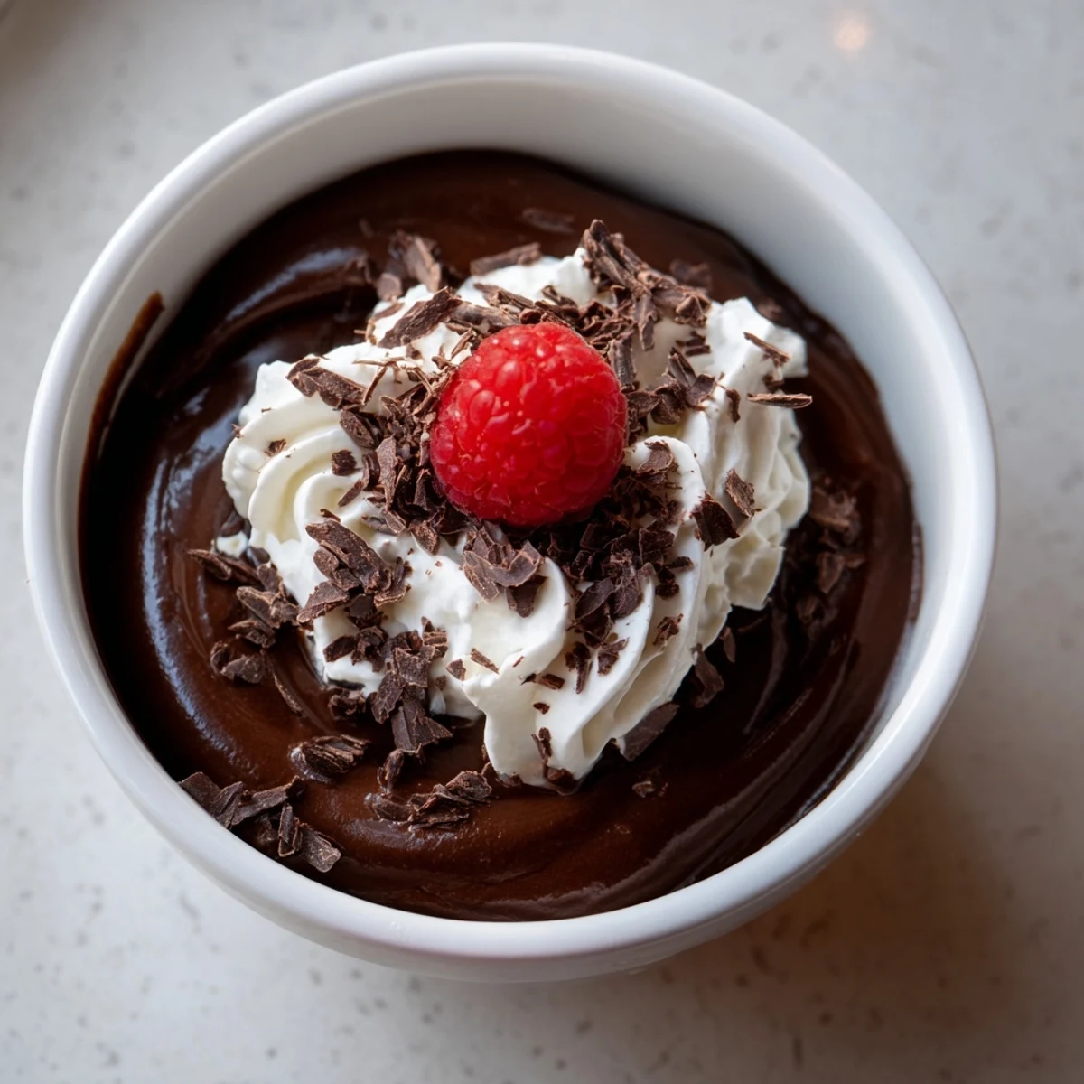 Glass dessert cups hold layers of Chocolate Lunch Dessert mousse topped with fresh raspberries and grated chocolate.