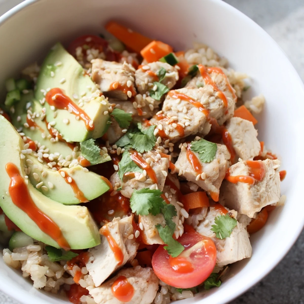 Colorful vegetables, avocado slices, and zesty lime garnish a freshly assembled, protein-packed Spicy Lunch Bowl.