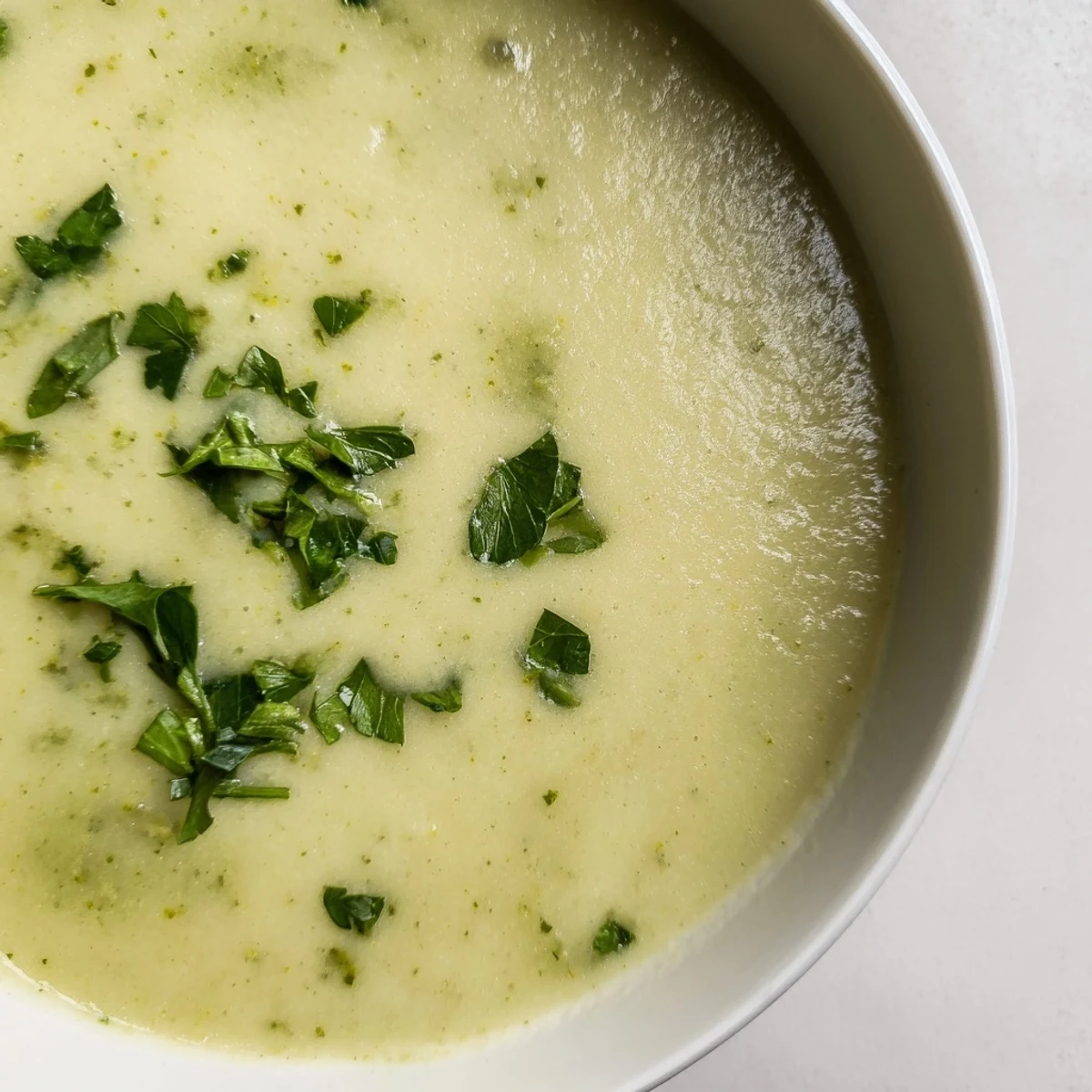 Creamy Lunch Soup in a rustic bowl, garnished with fresh parsley and steam rising from the velvety surface.