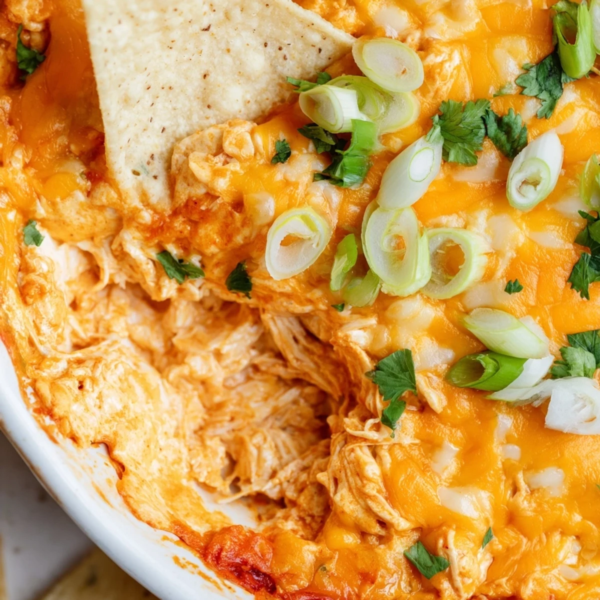 Creamy Spicy Buffalo Chicken Dip with shredded chicken and tangy hot sauce, ready to scoop with crunchy tortilla chips for game day.