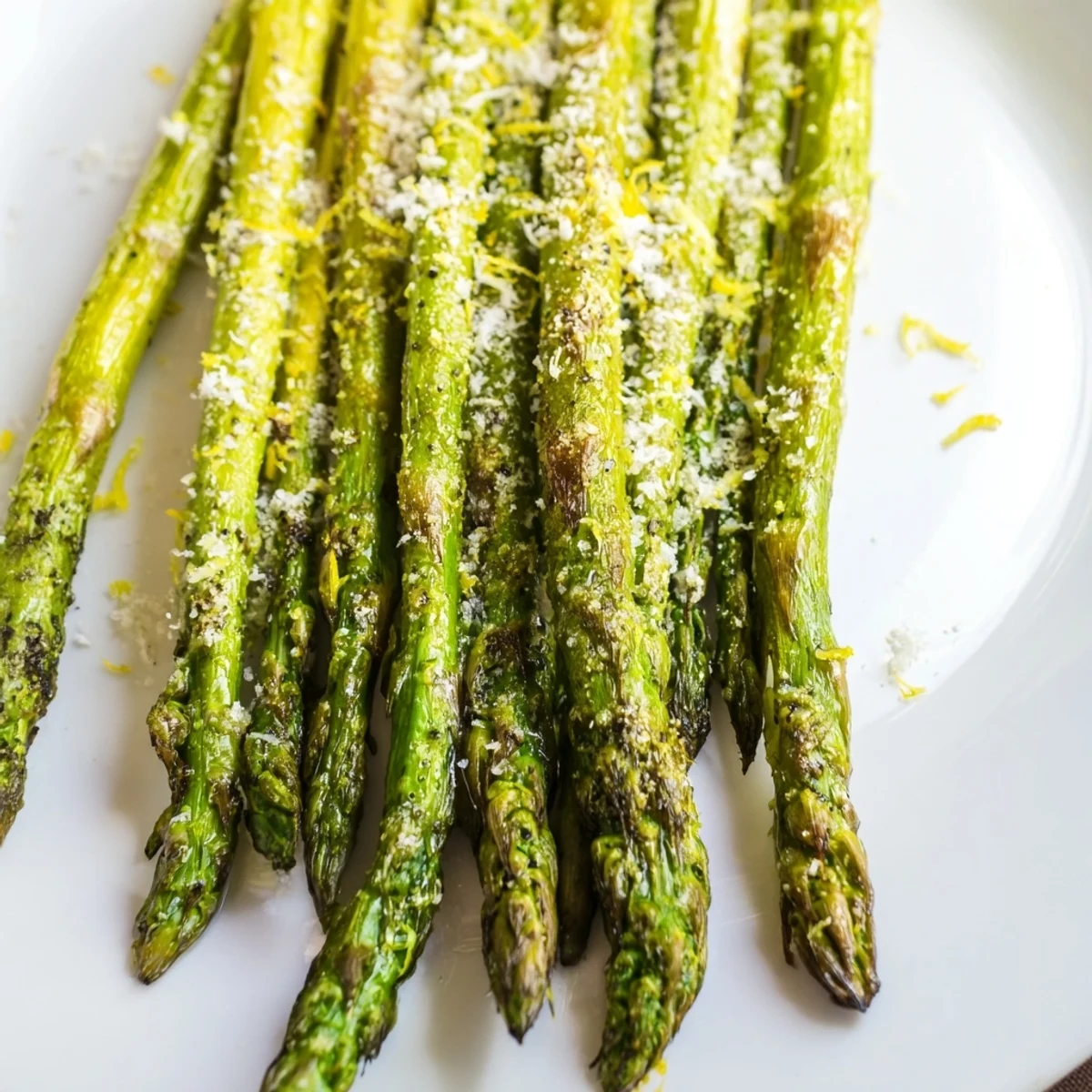 Tender roasted asparagus with Parmesan and lemon, plated alongside grilled chicken for a vegetarian dinner.