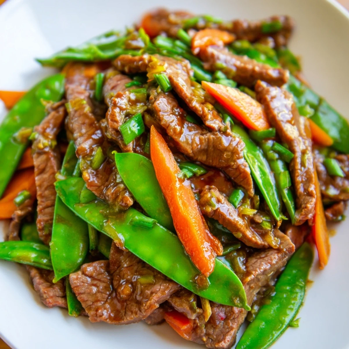Freshly stir-fried beef with snow peas, carrots, and ginger for a quick, flavorful weeknight dinner over steamed rice.