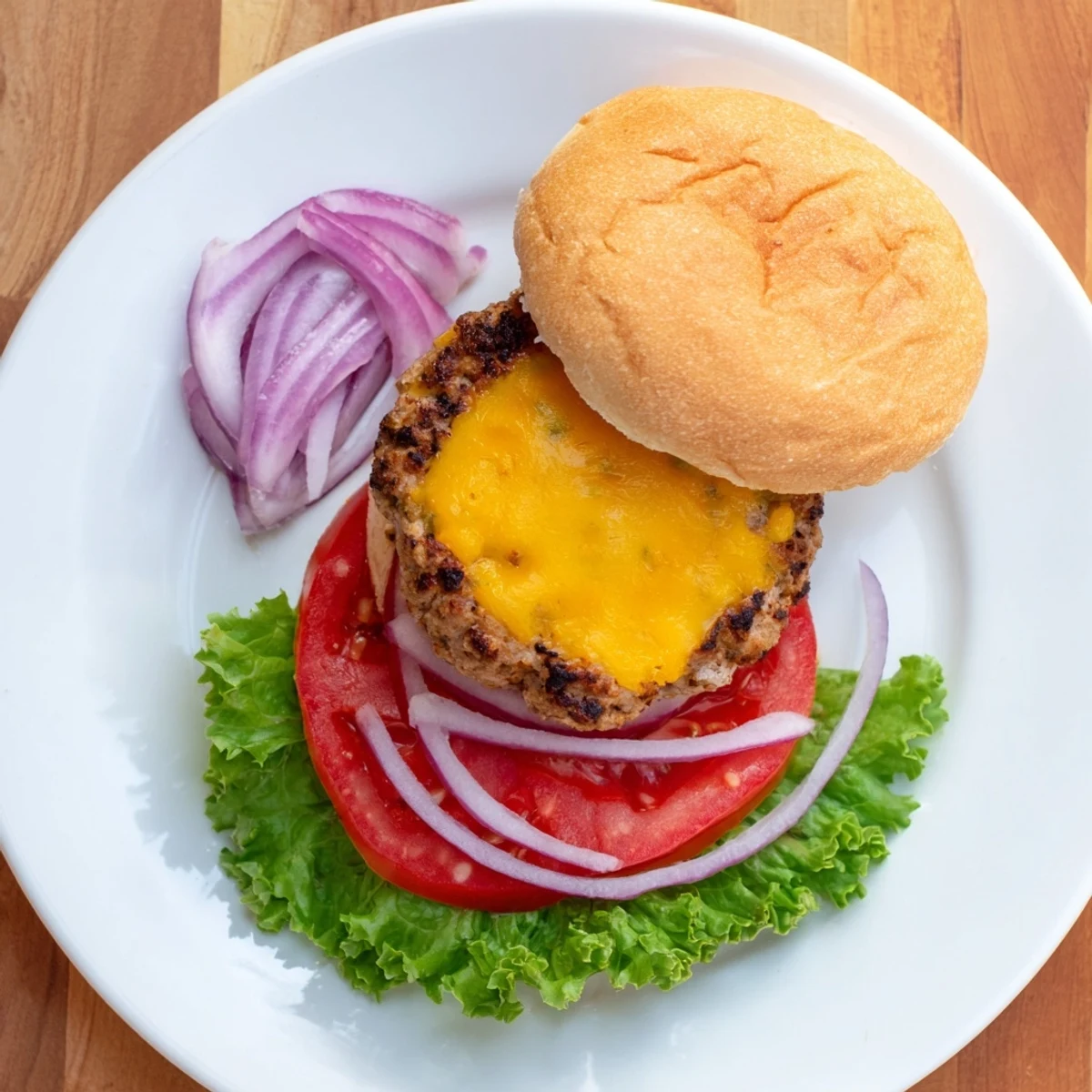 Melted cheddar drips down the sides of a juicy Turkey Burger with Cheese, served with red onion and ketchup.  