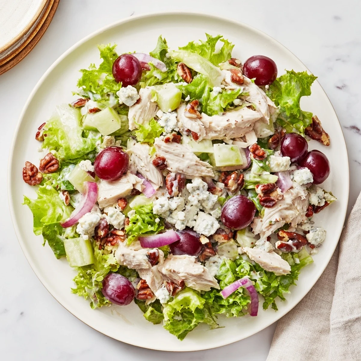 Tender diced chicken and toasted pecans tossed with crisp greens, red grapes, and creamy feta in a tangy dressing for a hearty lunch salad.  