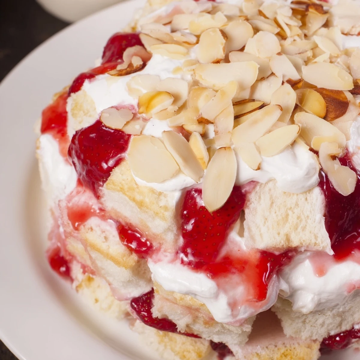 Serve this chilled Heaven on Earth Cake at summer gatherings, featuring airy cake layers, smooth pudding, and glossy strawberry topping in a clear dish.