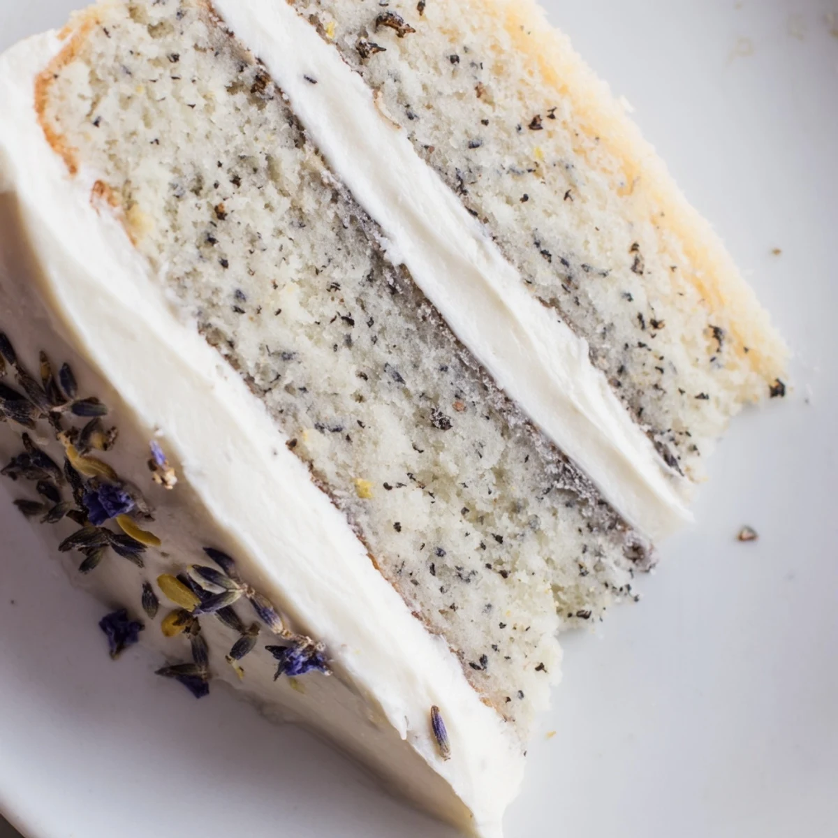 Three layers of London Fog Cake with Earl Grey & Lavender stand frosted and topped with dried lavender buds and lemon zest. 