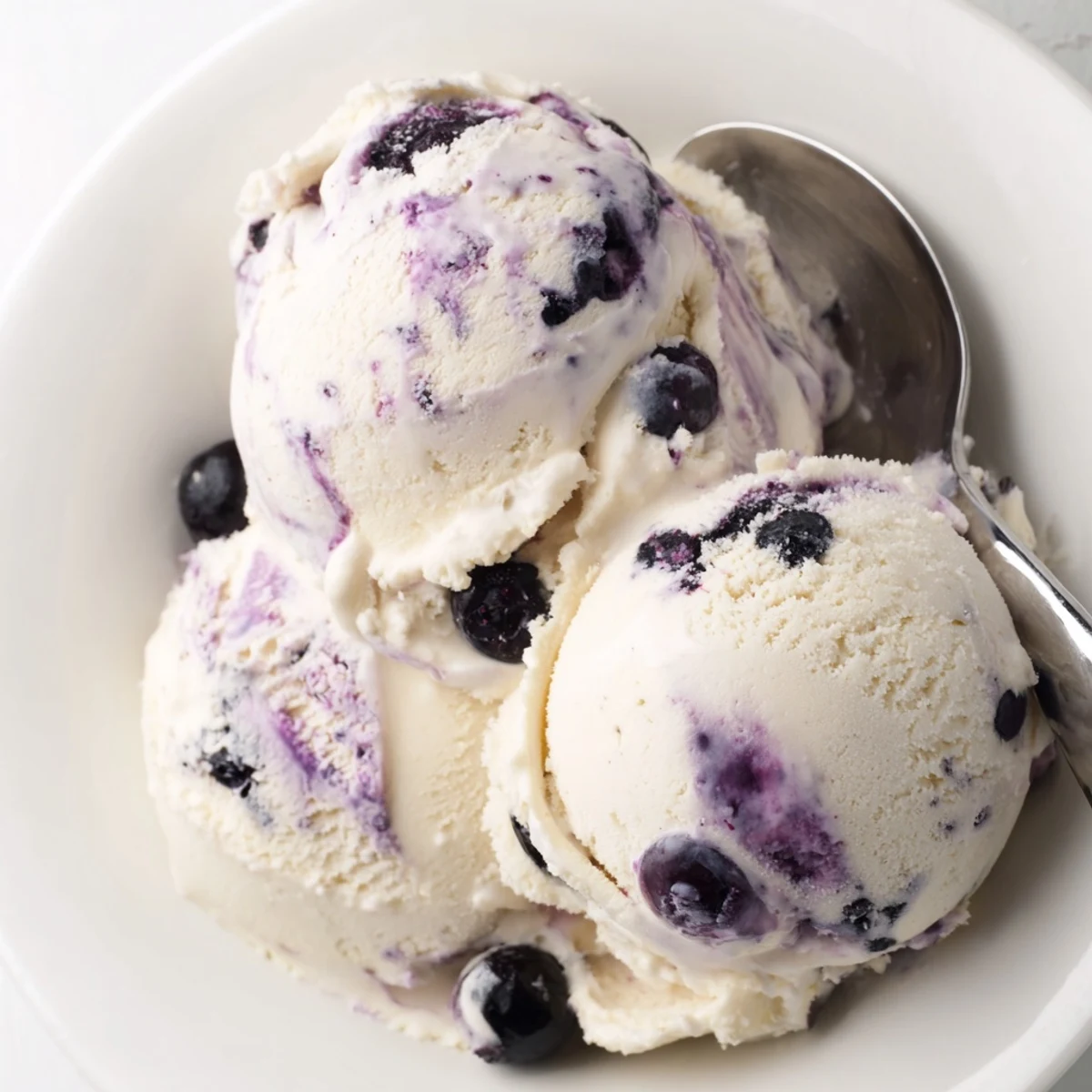 A close-up view of creamy Blueberry Cottage Cheese Ice Cream in a bowl, highlighting its smooth, protein-rich texture and berry swirls.