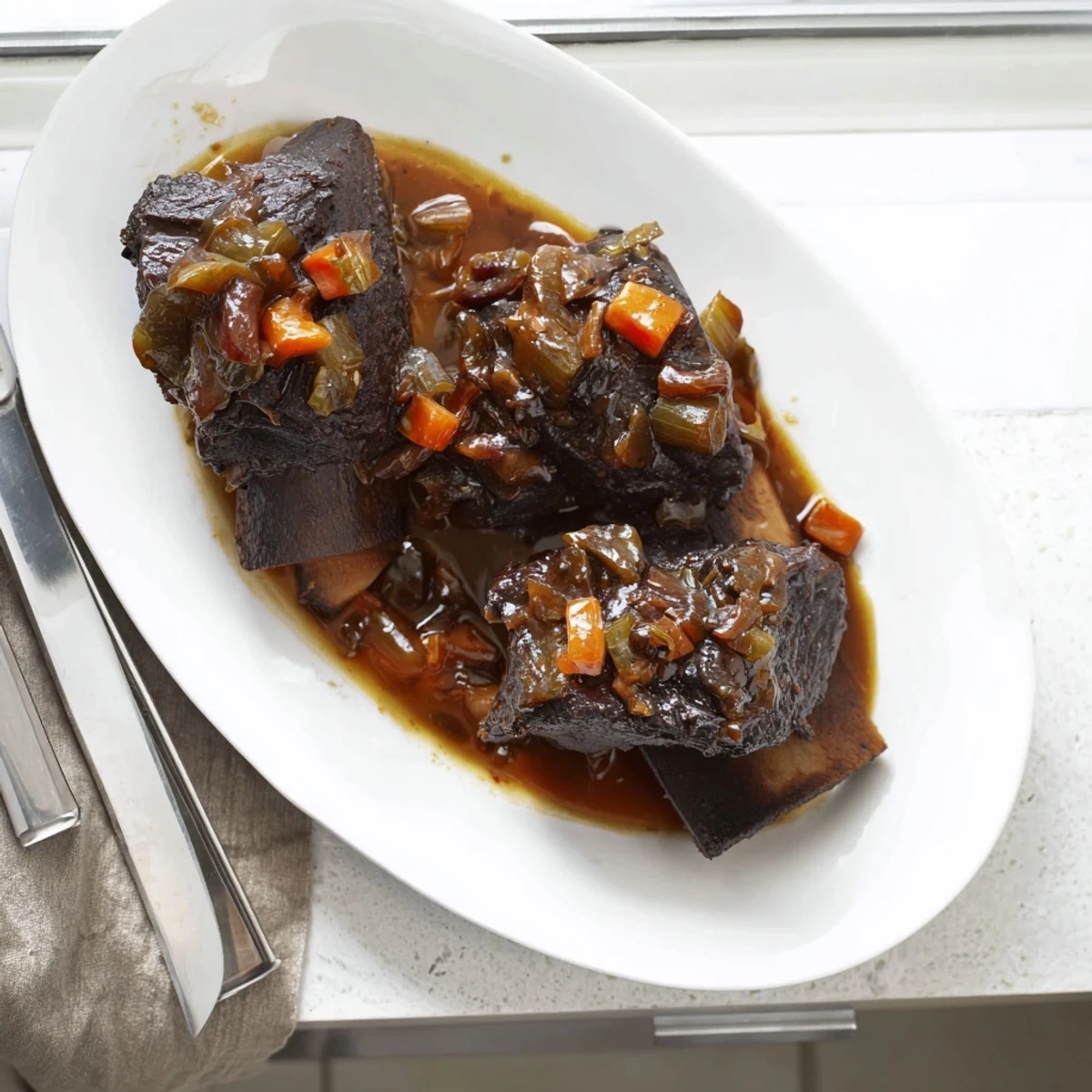 Maple Bourbon Glazed Short Ribs plated with roasted root vegetables, glistening glaze and savory aromas