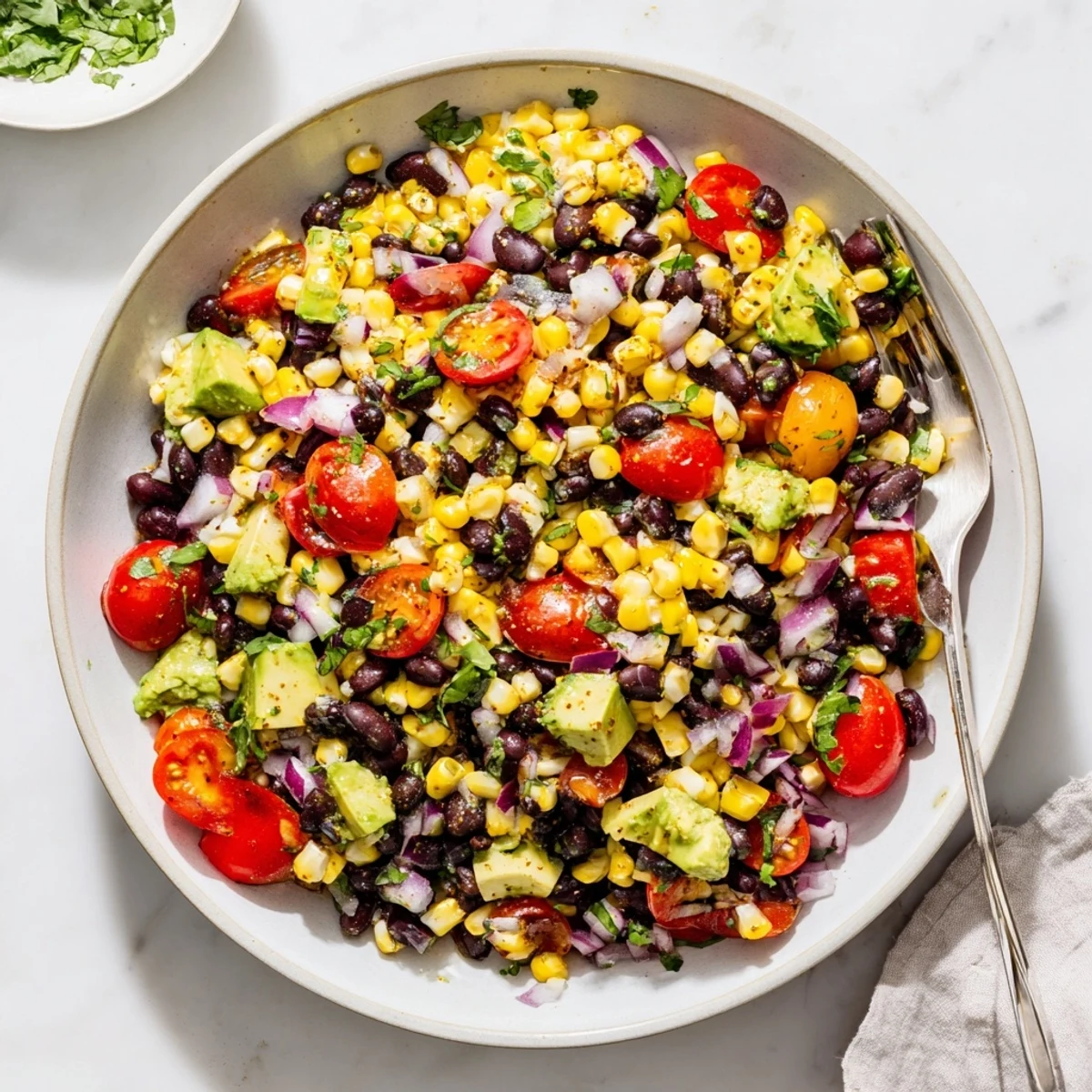 Fresh summer corn and black bean salad topped with cilantro and cherry tomato halves