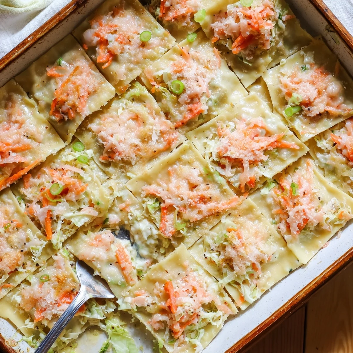 Sliced shrimp dumpling lasagna displaying cross-section of layered shrimp filling, melted cheese, and soft dumpling wrappers