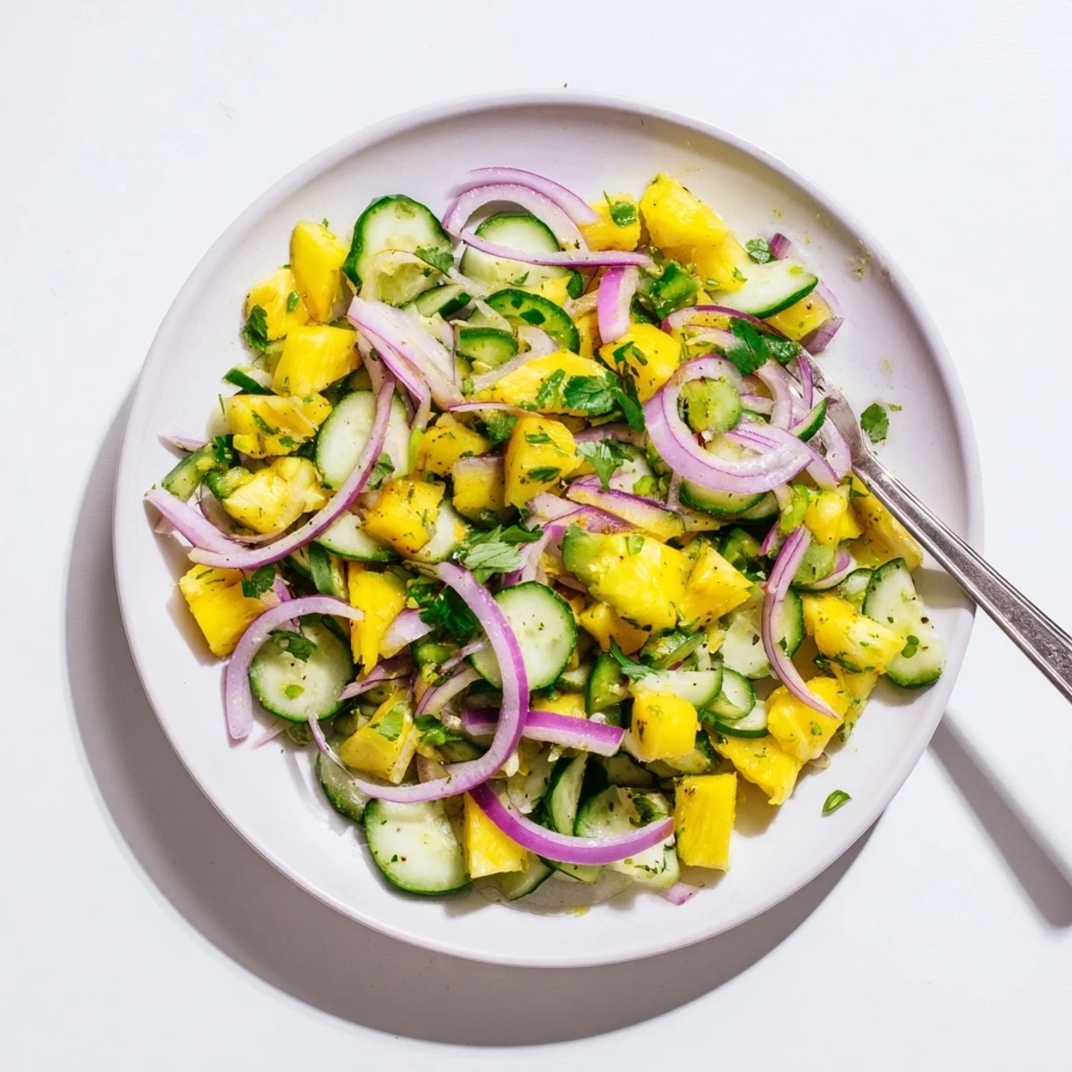 Vibrant bowl of pineapple cucumber salad tossed with zesty lime vinaigrette and fresh herbs