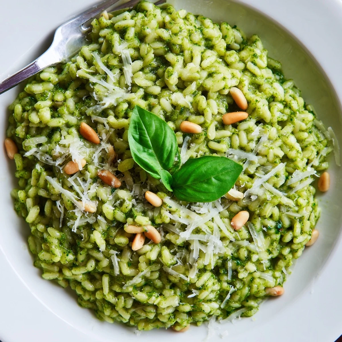 Golden Arborio rice stirred with vibrant green pesto and melted Parmesan cheese