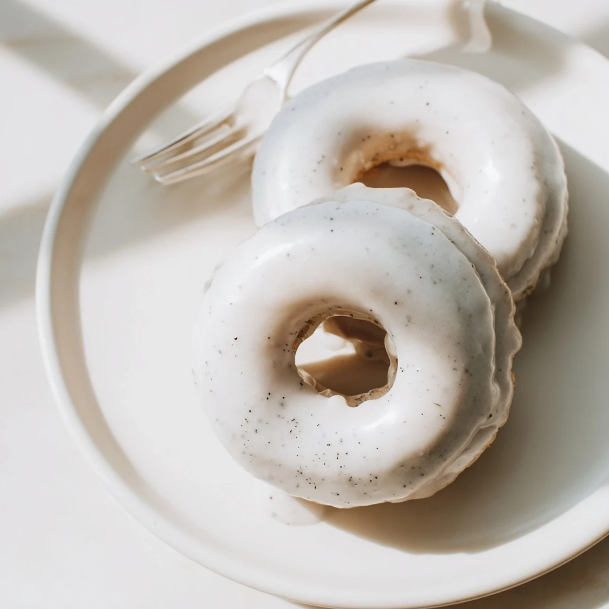 Golden brown Earl Grey mochi donuts topped with sweet white glaze on a wire cooling rack
