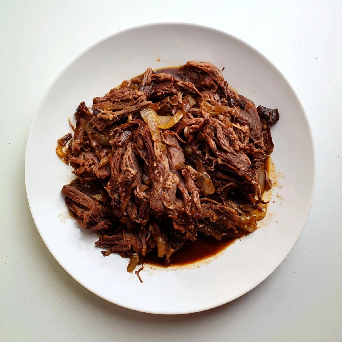 Fork-tender slow cooker shredded beef glistening with rich spices and beef broth