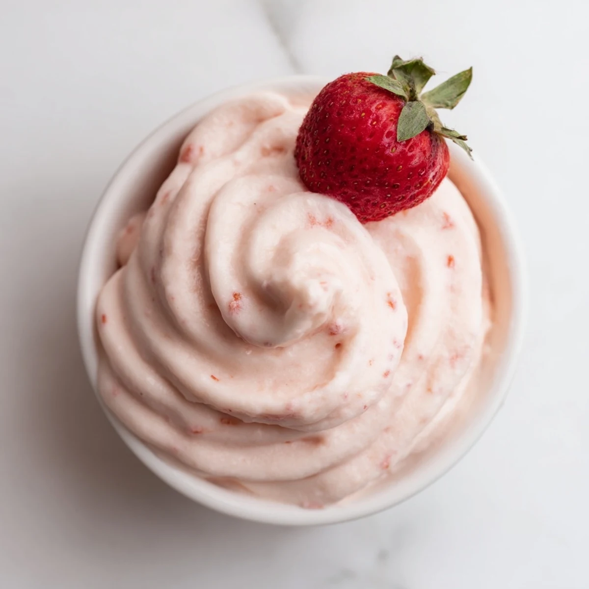 Vegan Frozen Strawberry Dole Whip Delight served in a waffle cone with toasted coconut flakes