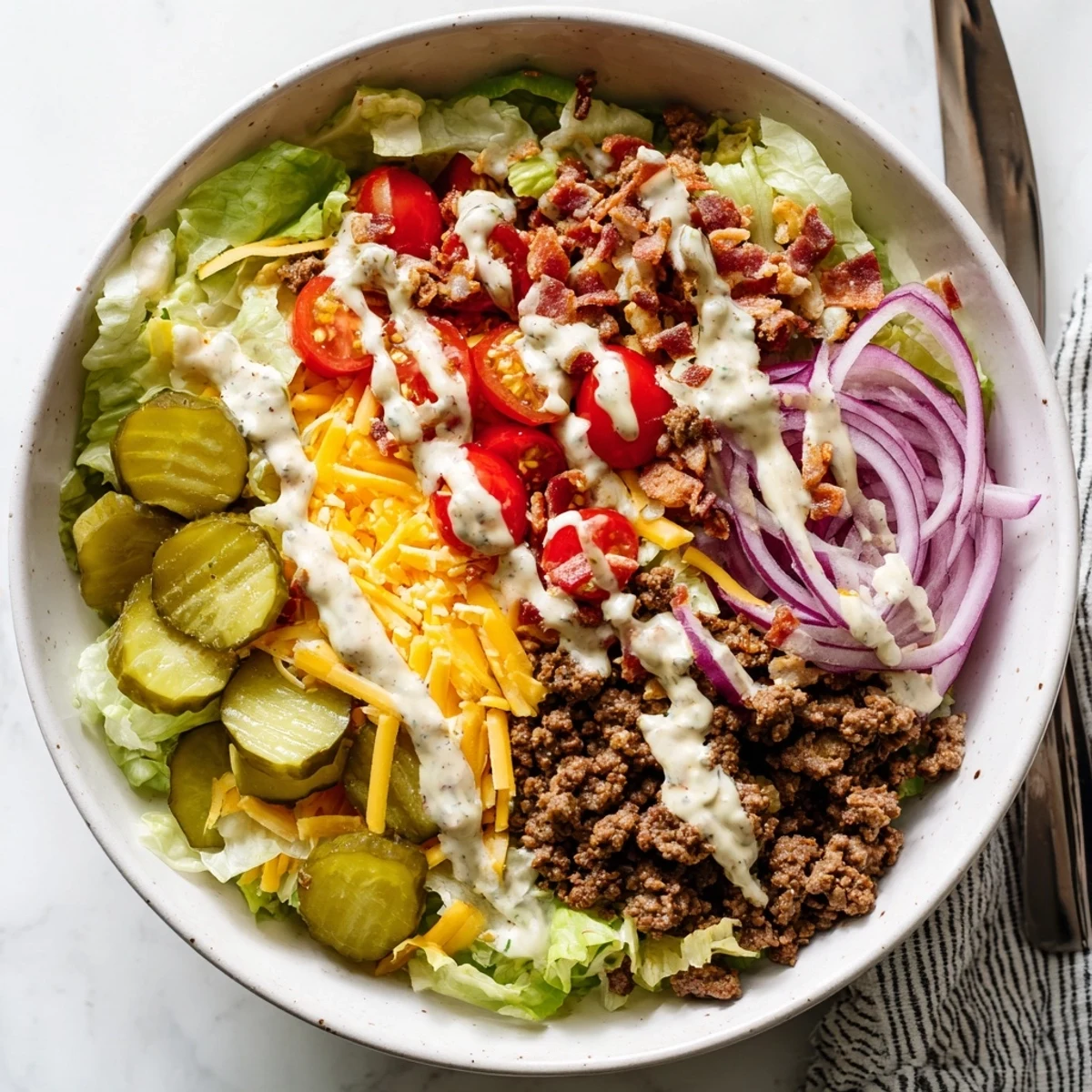 Deconstructed burger bowls featuring juicy seasoned beef layered with fresh vegetables and creamy homemade dressing for a gluten-free dinner
