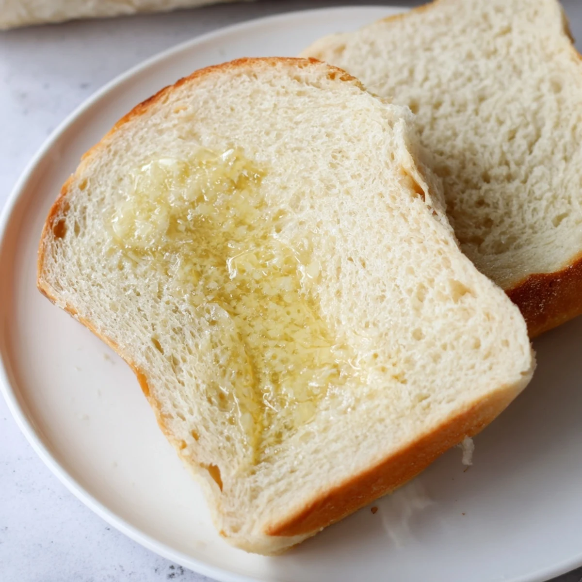 Golden homemade Amish white bread loaf fresh from the oven with glossy melted butter top