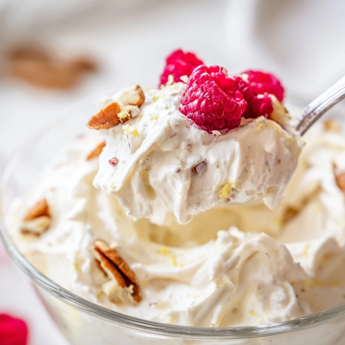 Light and airy keto cheesecake fluff swirled with whipped cream in small serving bowls