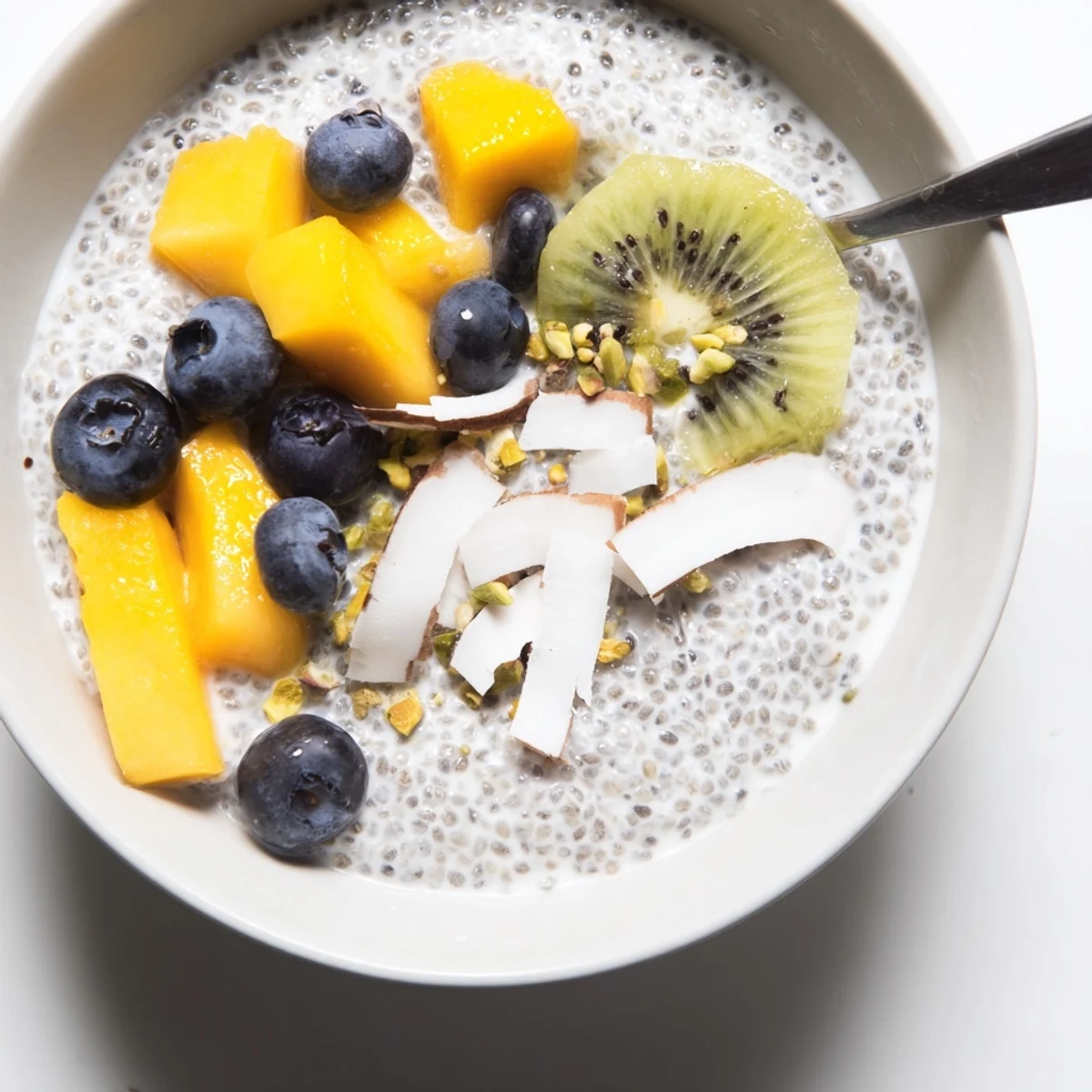 Coconut Chia Pudding topped with fresh mango and toasted coconut flakes