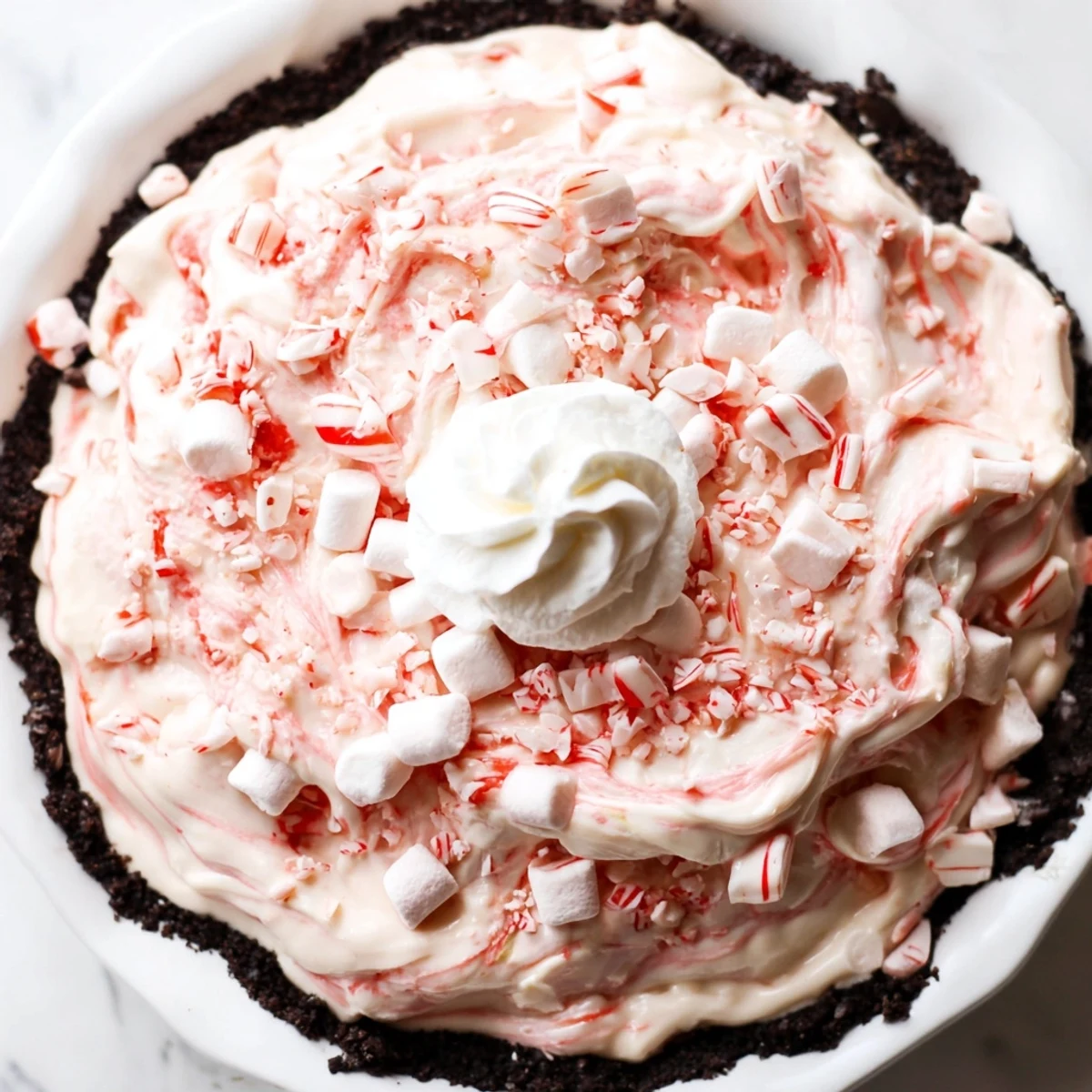 Candy Cane Pie with creamy peppermint filling and chocolate cookie crust slices.