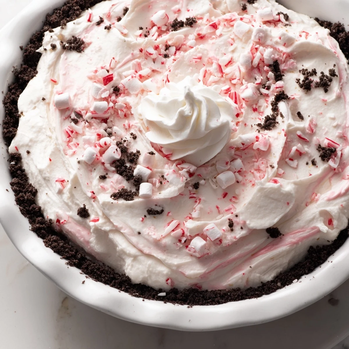 Chilled Candy Cane Pie topped with cloudlike whipped cream and peppermint crunch.