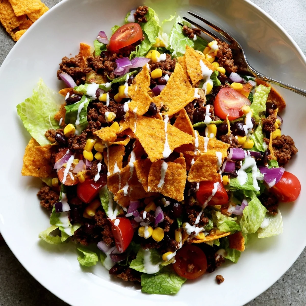 Bowl of Simple Doritos Taco Salad topped with ranch and extra crunch.