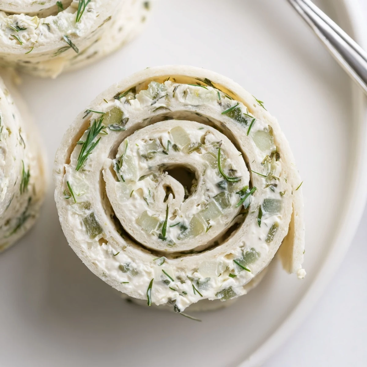 Pickle Dip Pinwheels arranged on platter, creamy filling and crunchy pickles.