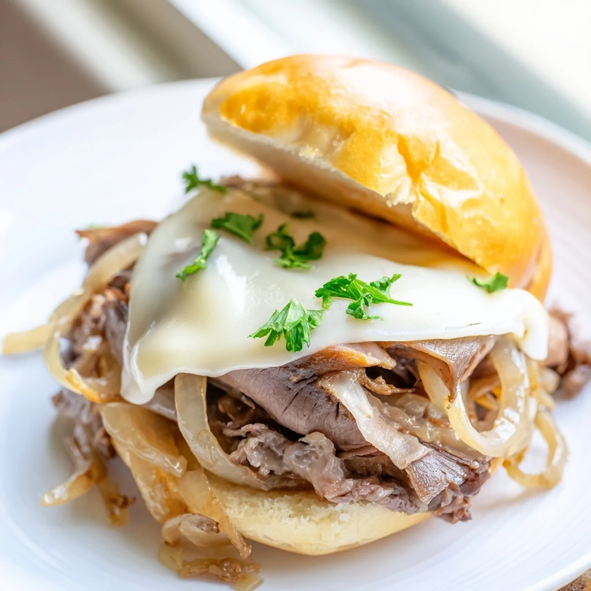 Baked French dip sliders featuring tender roast beef and melted cheese served alongside warm savory dipping sauce