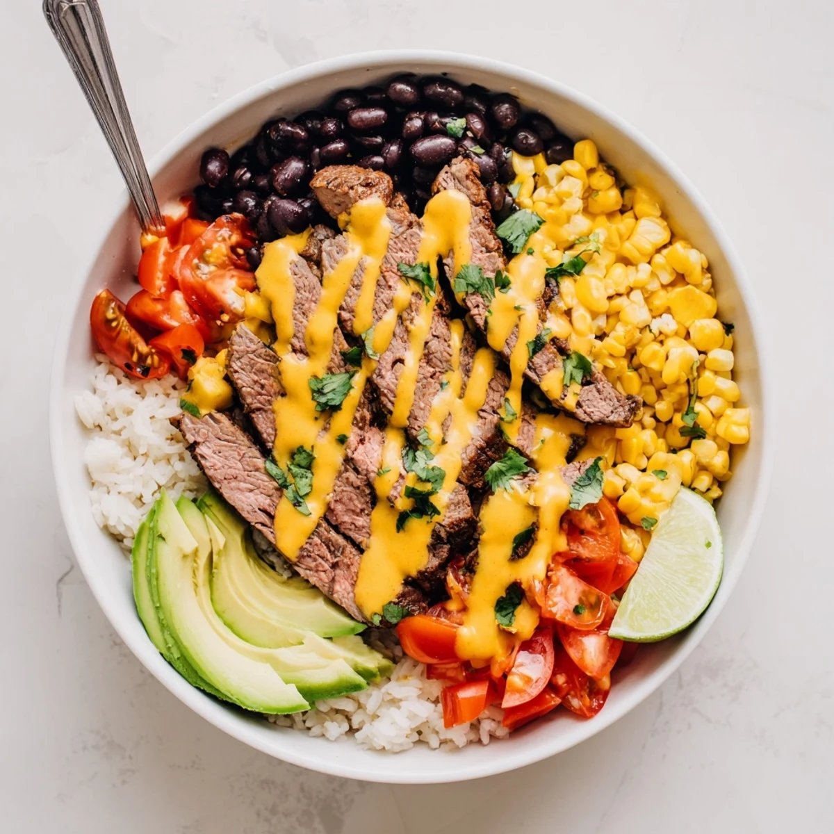Steak queso rice bowl topped with seasoned beef, melted cheese sauce, and fresh cilantro garnish