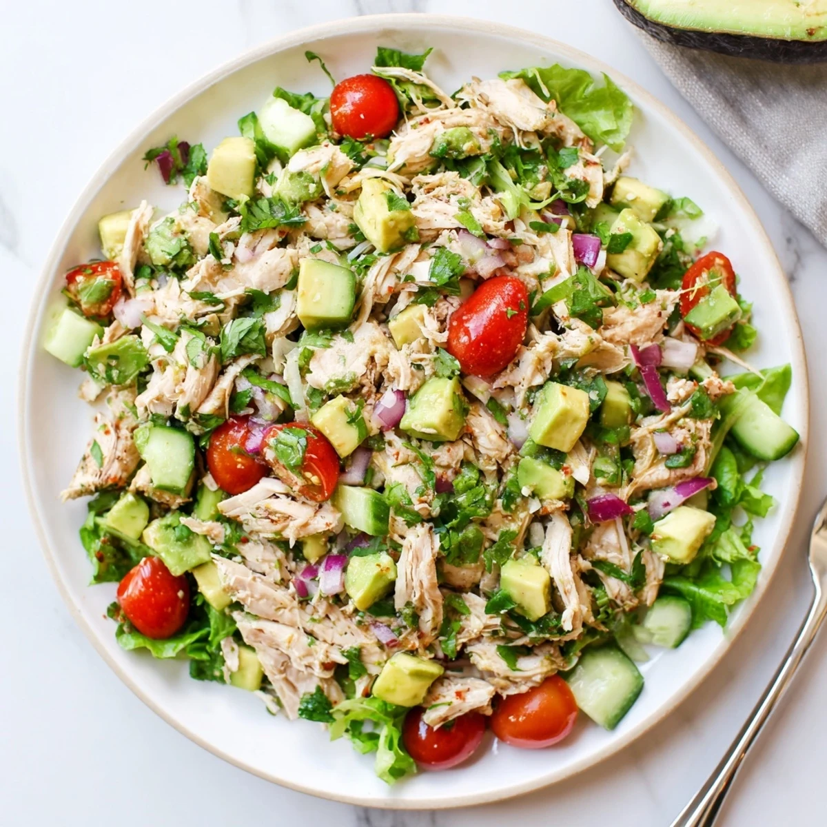 Avocado Chicken Salad tossed in zesty lime dressing, served on mixed greens
