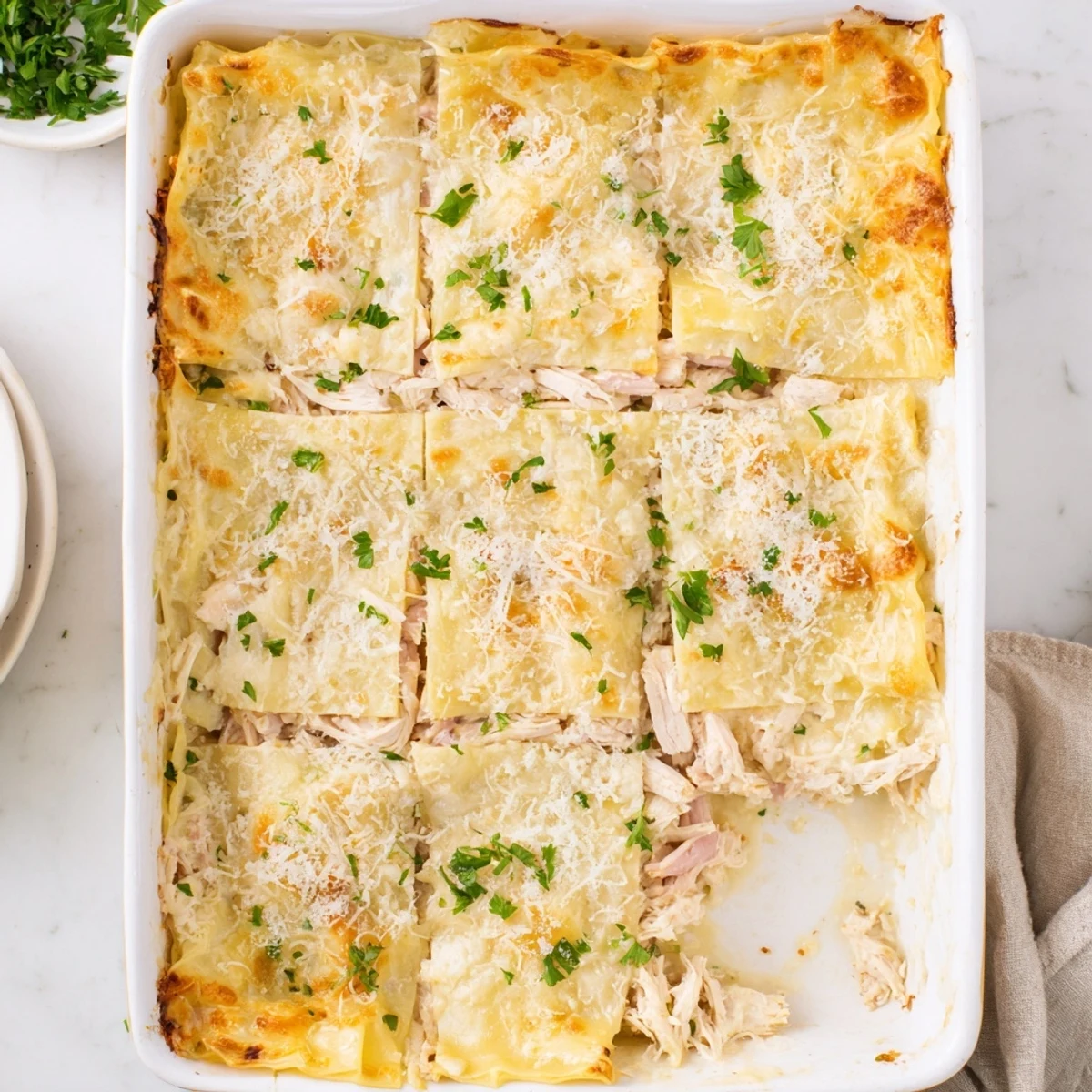 Golden chicken cordon bleu lasagna layers bubbling with melted Swiss cheese and savory ham slices
