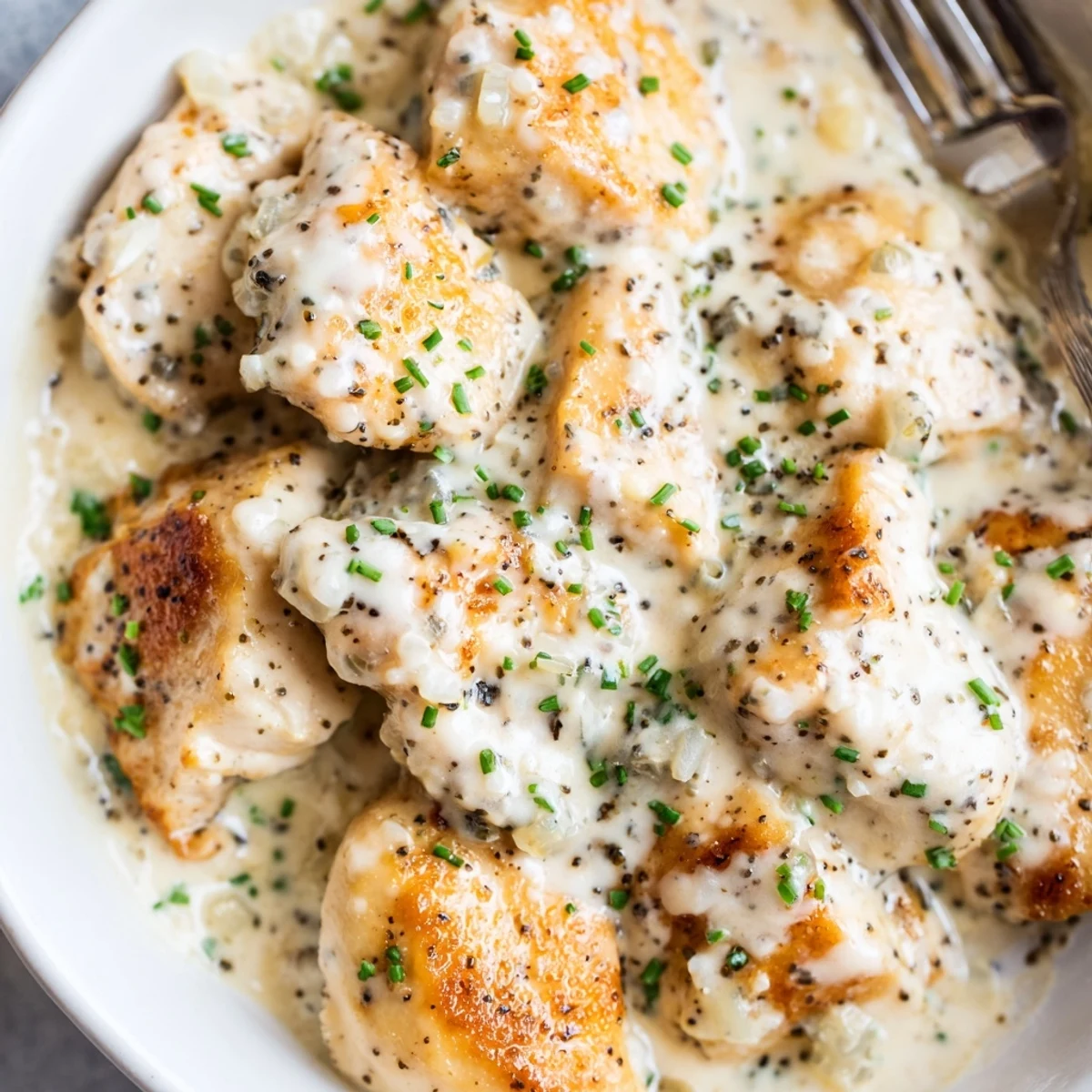 Creamy cream cheese chicken nestled in a golden garlic herb sauce on a plate