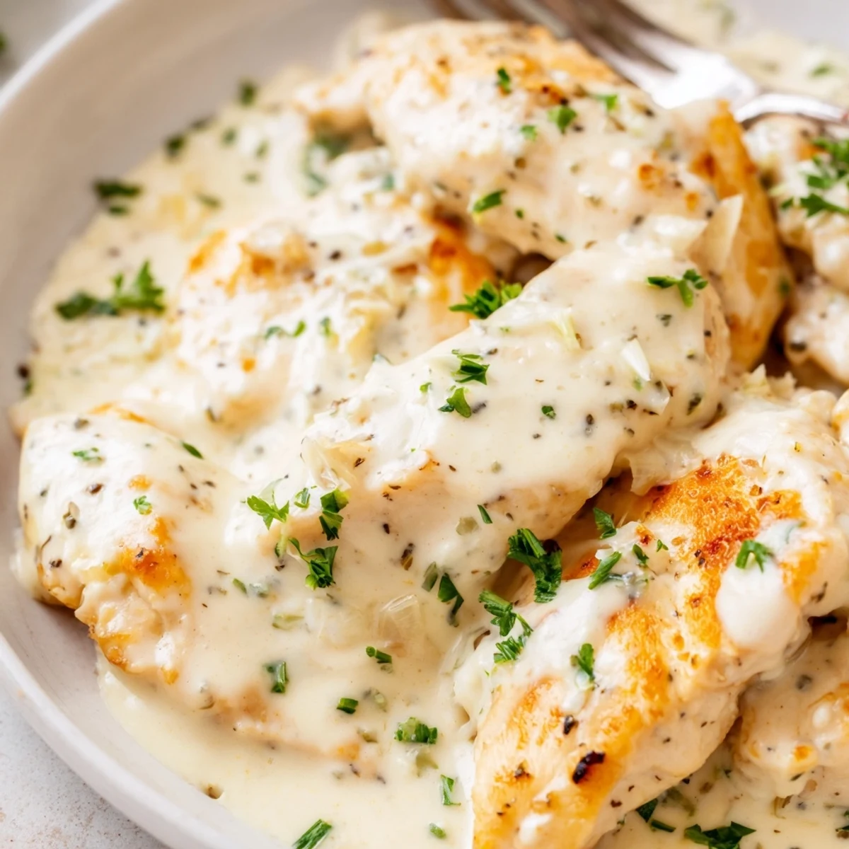 Tender cream cheese chicken smothered in a silky Parmesan sauce with fresh chives