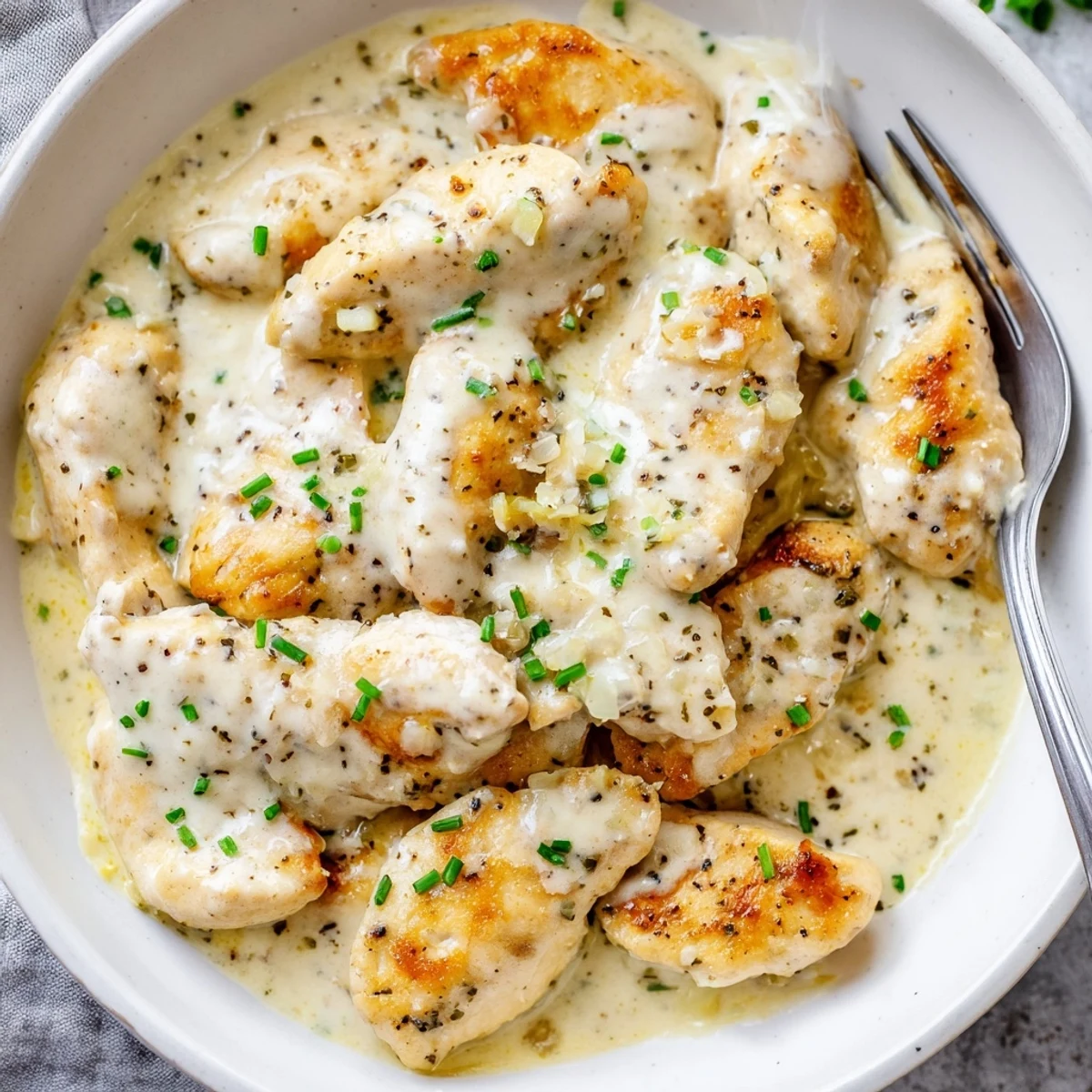 Cream cheese chicken breasts coated in a rich, velvety dairy sauce ready to serve