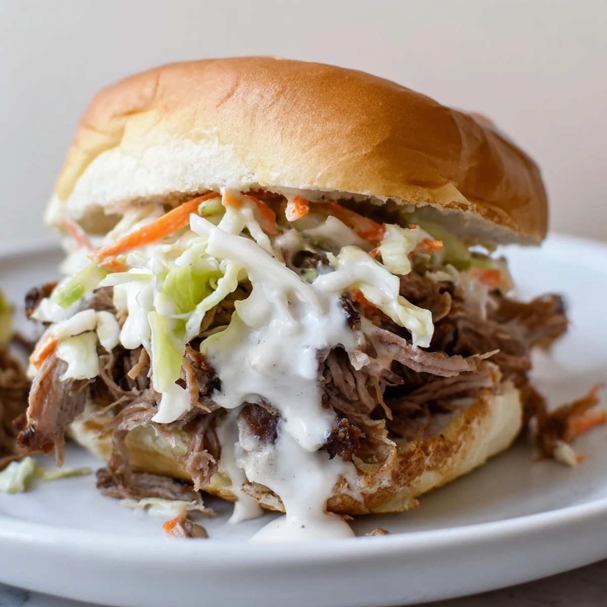 Juicy Alabama white sauce pulled lamb sliders piled with crunchy creamy slaw on toasted buns