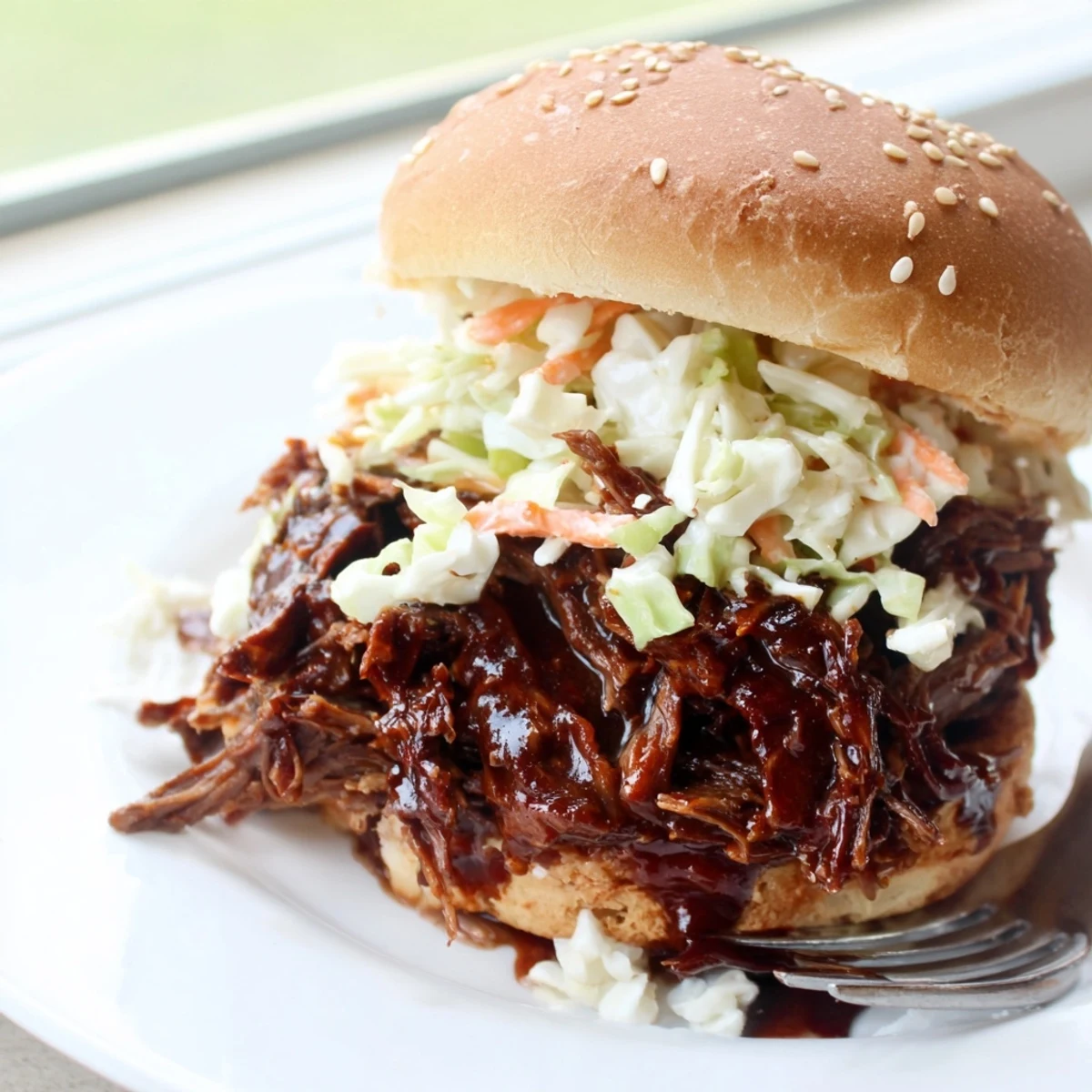 Hearty Slow Cooker BBQ Pulled Beef served over fluffy white rice with tangy sauce