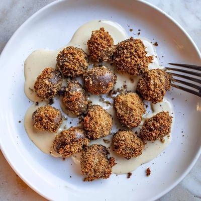 Warm Chicken Fried Mushrooms with Gravy beside buttery biscuits, crispy texture and rich, velvety sauce ready to savor.