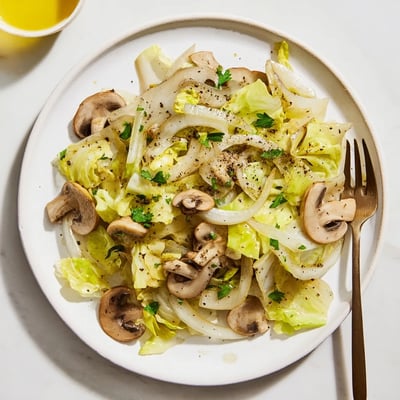 Warm Vegetarian Cabbage Mushroom Sauté served in a white bowl, ready to be paired with quinoa.