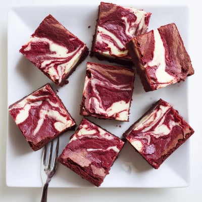 Fudgy Red Velvet Cheesecake Brownies with crackly tops, perfect with a glass of cold milk.