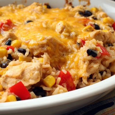 A hearty casserole dish with tender chicken, fluffy rice, and melted Mexican cheese blend ready to serve.