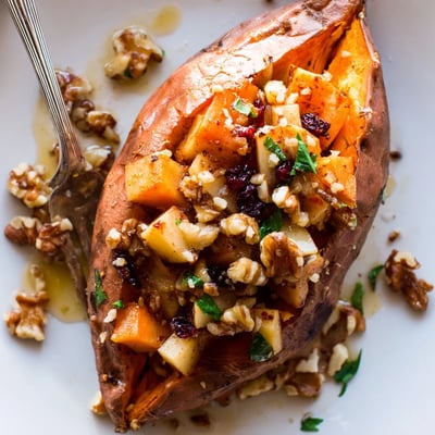 A serving of Stuffed Sweet Potatoes With Apples, warm, topped with crunchy walnuts