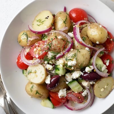 Bright Olive Greek Potato Salad with tangy herb dressing, feta crumbles, crisp cucumber.