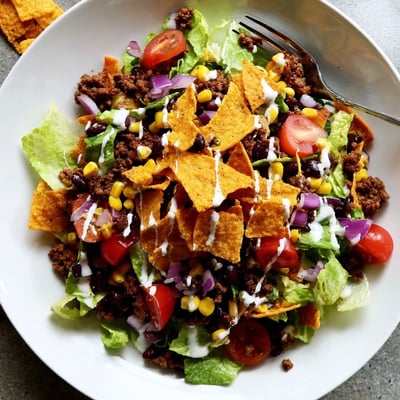 Bowl of Simple Doritos Taco Salad topped with ranch and extra crunch.