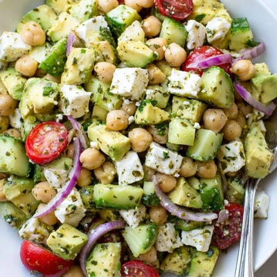 Colorful chickpea feta avocado salad with cherry tomatoes and fresh herbs