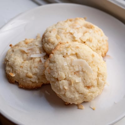 Soft and buttery coconut cookies stacked on a rustic plate for teatime serving