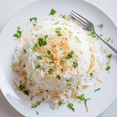 Fragrant coconut rice served in a bowl alongside vibrant Thai green curry